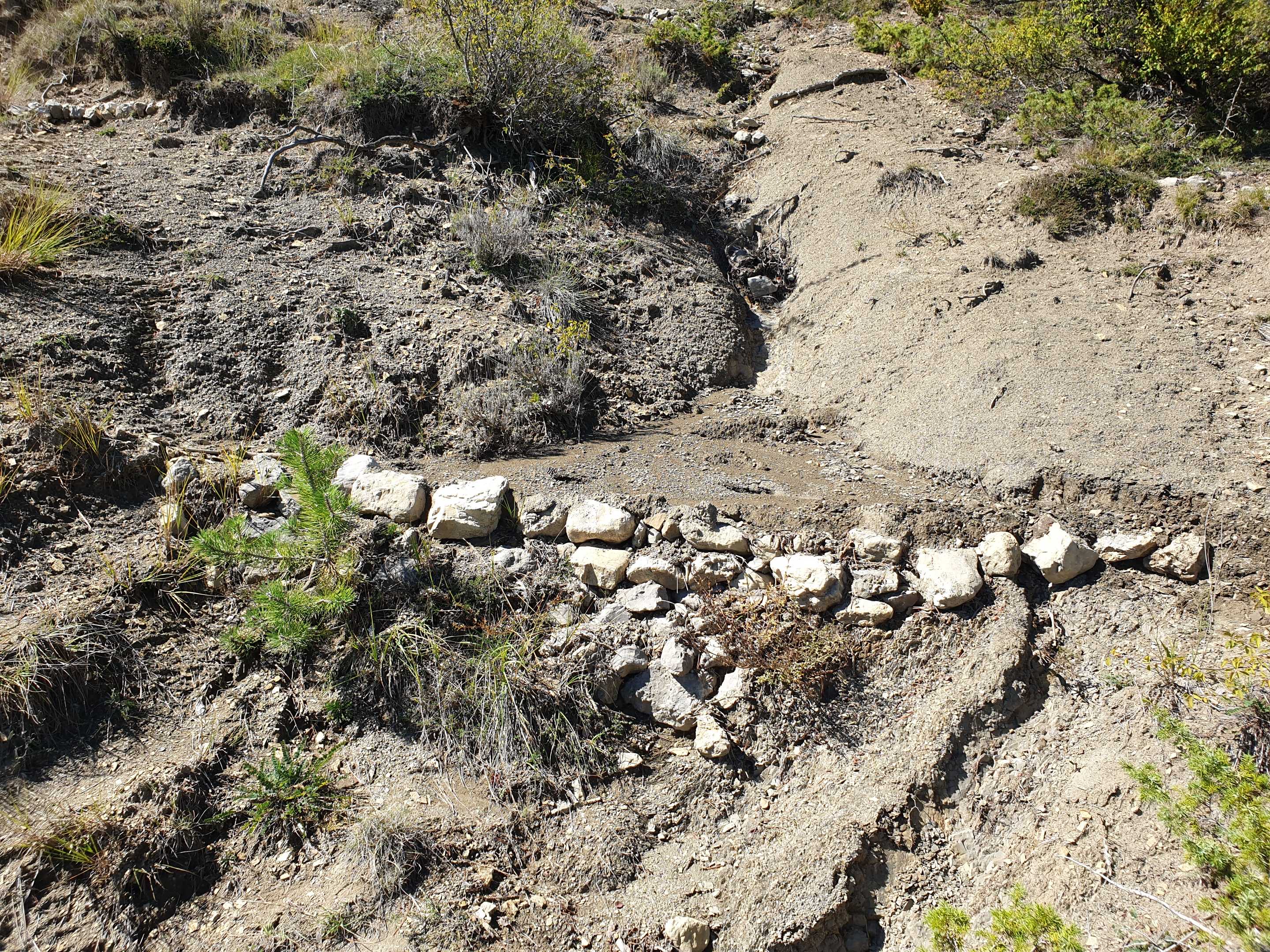 Conservation de l'humidité et du sol sur une surface imposante en amont d'un barrage fait de pierre et de terre.